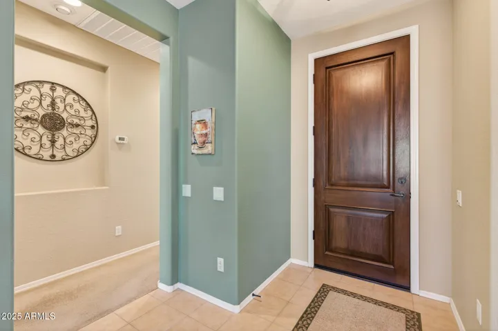 The foyer has a gorgeous wooden door entry.