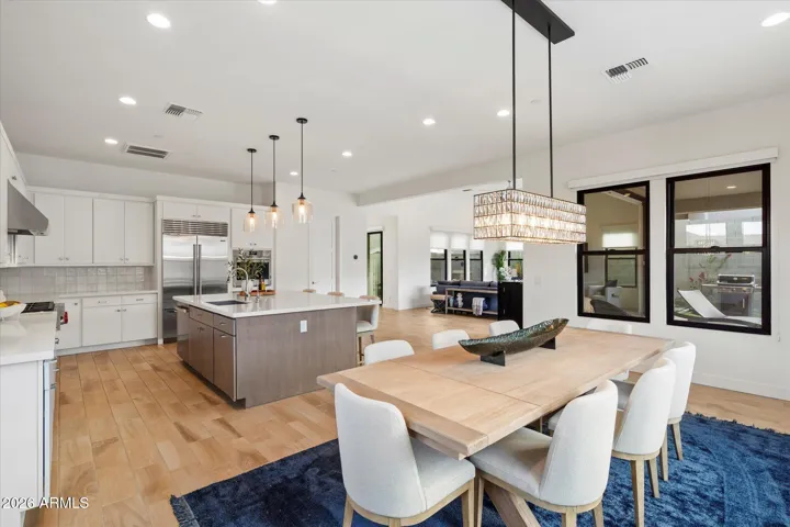 Contemporary dining area with statement lighting, large windows, and seamless connection to the kitchen. Ideal for formal dinners or everyday meals in this Scottsdale luxury home.