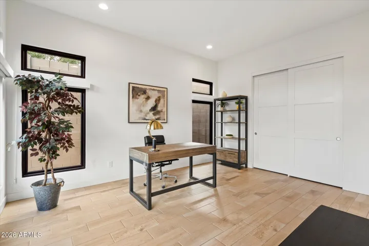 Bright casita interior with modern finishes and wood-look flooring. Full Bath, closet space and kitchenette. Perfect for visitors or a private retreat within this Scottsdale home.