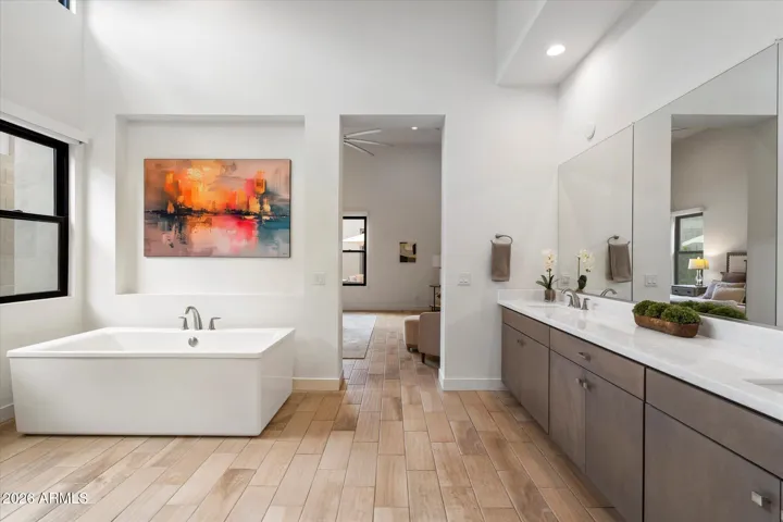 Elegant primary bathroom featuring a freestanding soaking tub, clean modern lines, and abundant natural light. This Scottsdale luxury home offers a serene, spa-like retreat with high-end finishes.