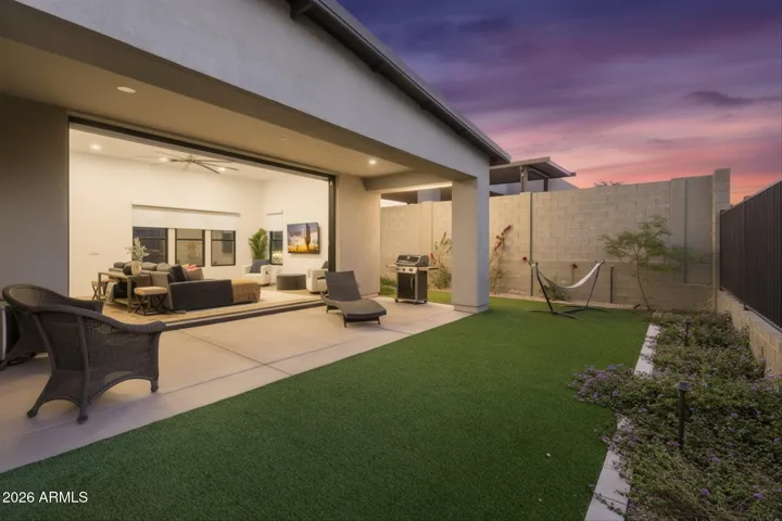 Inviting backyard with covered patio, artificial turf, and seamless indoor-outdoor living. Perfect for entertaining and low-maintenance Scottsdale living.