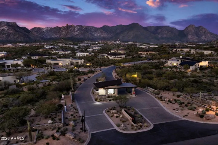 Evening aerial view of the Sereno Canyon guard house highlighting the professionally staffed gate and beautifully landscaped entry into this exclusive Scottsdale enclave.