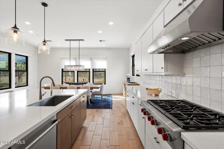 High-end kitchen featuring Wolf, Asko premium appliances, custom cabinetry, statement hood, and modern tile backsplash. A standout feature for luxury living in Scottsdale.