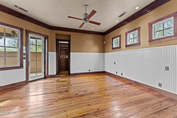 Accented with Wainscoting, Crown Molding, and Door to Private Patio