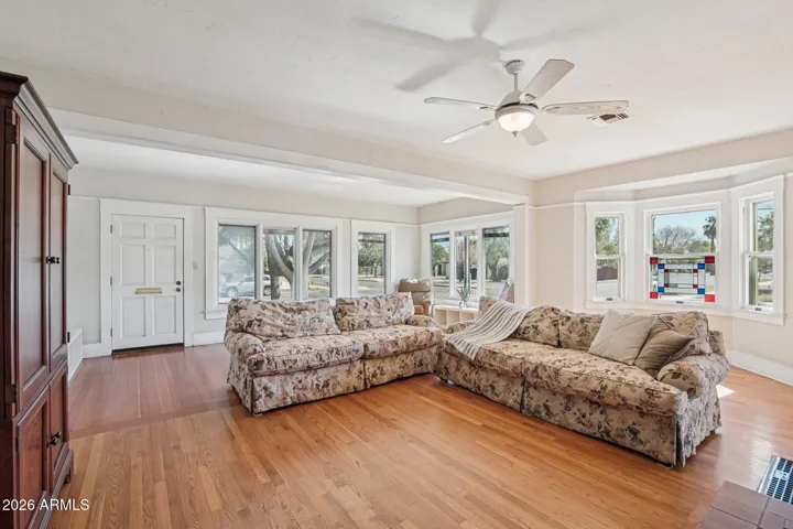 Grand living room with lots of light. Tall ceilings and wood floors. Beautiful bay window with stained glass