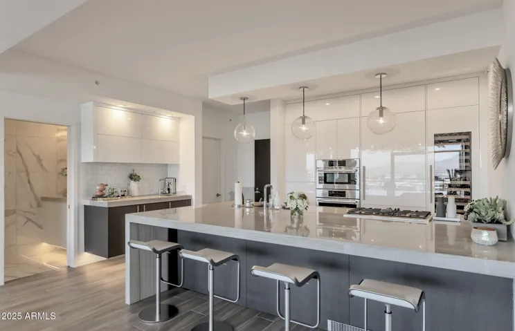 Largest 1-bedroom + den in Optima Kierland 7120. This 9th floor original 2-bedroom unit floorplan is reimagined to expansive updated 1-bedroom + den executive condo. Sub-Zero, Miele, Bosch appliances, Wine Fridge, Wine Wall, Bar, 3-way Fireplace, NE Mountain and Courtyard Views.