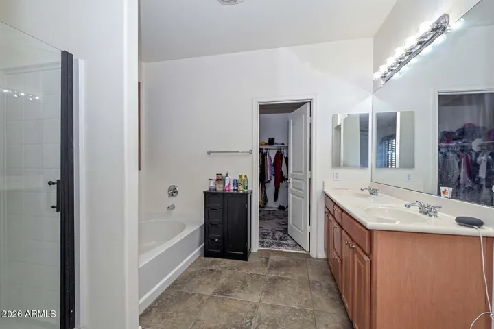 Spa-like private bath with dual sink vanity and separate shower/soaker tub.