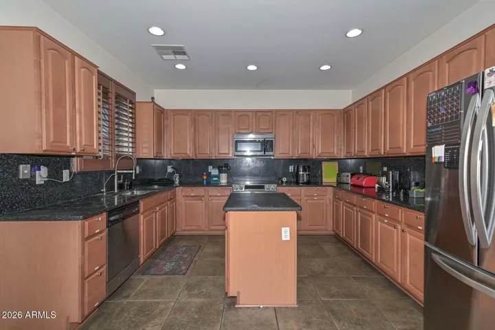 Updated kitchen features; black granite counters & backsplash, lots of cabinets & stainless steel appliances!