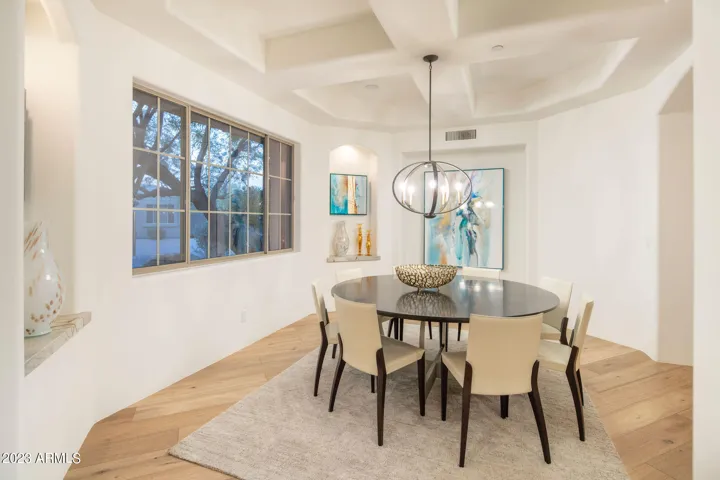 An elegant dining space with showcasing the 7,000 sf of wide-plank wood flooring and easy flow to living areas.