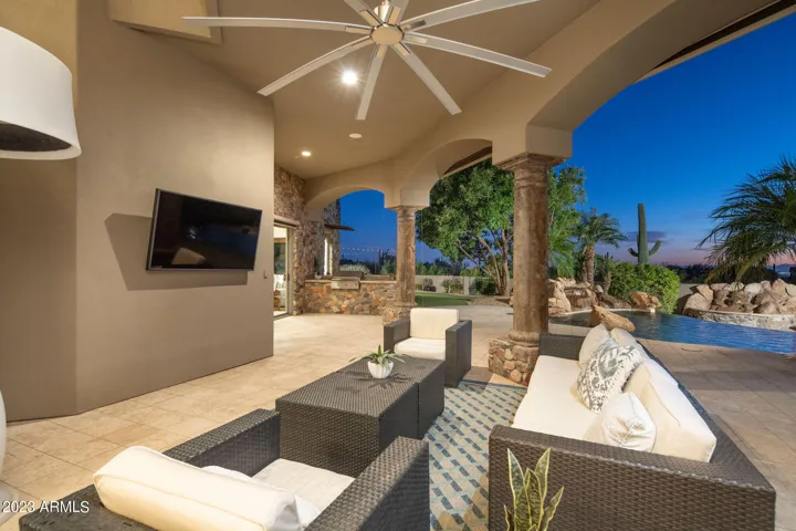 Expansive covered patios, some with drop down screens for shading and an outdoor TV , along with a BBQ and bar top area create multiple outdoor areas surrounding the pool and spa.