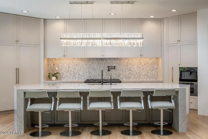 Enjoy a modern kitchen designed for both culinary creativity and entertaining, featuring a spacious waterfall island and top-of-the-line Dacor, KitchenAid, and JennAir appliances that make every meal feel like a work of art.
