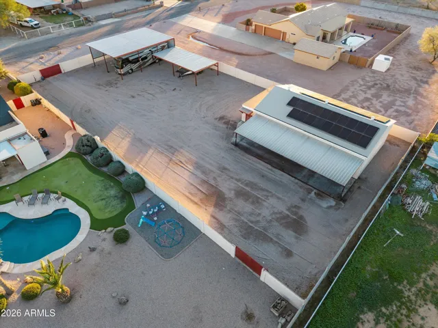 Wide aerial view showing the relationship between the shop, RV carports, and the main home’s pool area. Clearly illustrates the versatility of the property and the intentional layout across the grounds.
