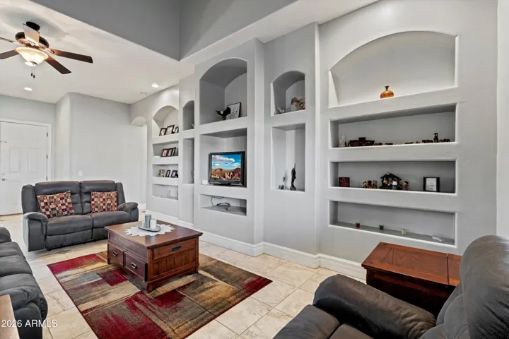 Built-in wall niches add character and display space to the living room. The layout supports multiple furniture arrangements while maintaining clear flow to the kitchen and dining areas.