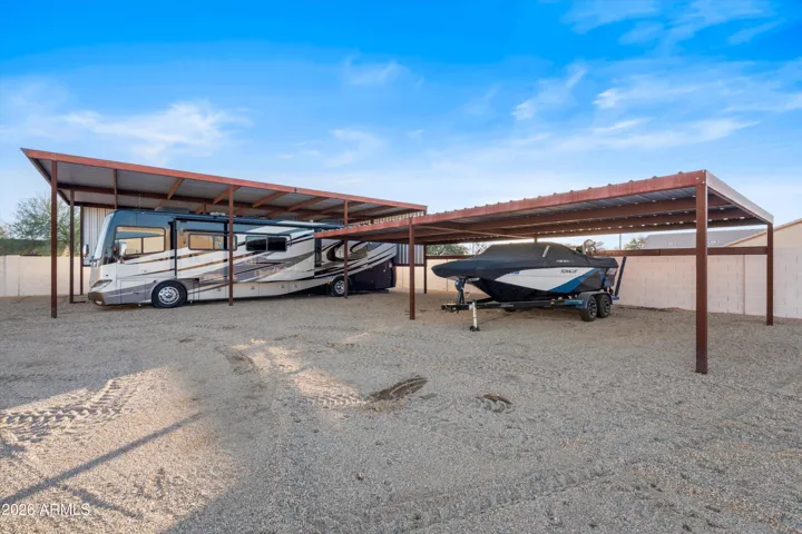 Spacious covered carport with room for four vehicles, trailers, or recreational equipment. Boat shown does not convey.