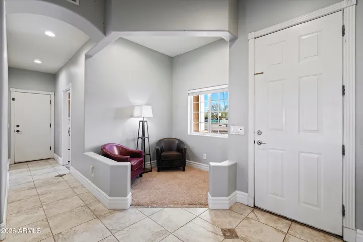 Just inside the entry is a small foyer seating area, the only carpeted space in the home. This defined nook offers a comfortable transition space before opening into the main living areas.