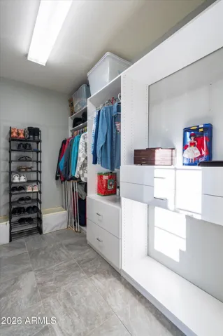 The walk-in closet includes a built-in organizer system with shelving, drawers, and hanging space. Designed for efficiency and storage, this closet supports long-term organization and ease of use.