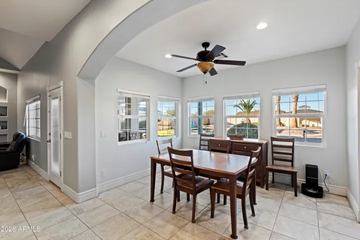The dining area features multiple windows that bring in natural light and views of the surrounding property. Positioned just off the kitchen, this space works well for everyday meals or larger gatherings.