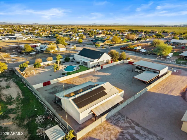 Expansive aerial showcasing the full layout of the property, including the main residence, pool area, detached shop, RV carports, and wide open grounds. Highlights the rare scale and separation of living, recreation, and work spaces.
