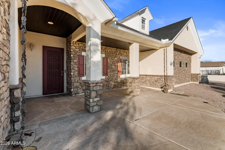 A covered front patio offers space for outdoor seating and personal décor. This inviting area adds charm and functionality, creating a quiet spot to relax or greet guests.