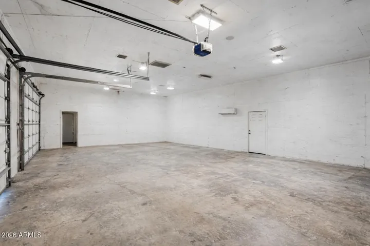 Large workshop interior with high ceilings and ample lighting. All equipment, vehicles, and materials shown will be removed prior to close of escrow.