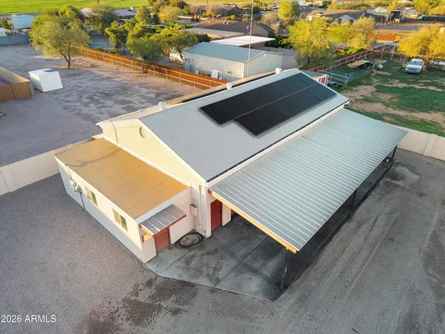 Aerial view of the detached shop showing one side of the paid-in-full solar panel system. Demonstrates the scale of the shop and its separation from the main living areas.