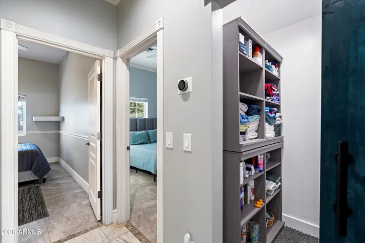 A hallway storage closet features a sliding barn door, adding both function and character. Conveniently located between the secondary bedrooms, this space offers easy access for linens, storage, or daily essentials.