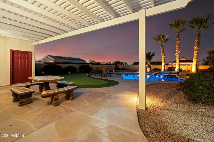 Pergola-covered seating area with solid concrete furniture included. Designed as a permanent outdoor gathering space that enhances the backyard’s resort-style layout and functionality.