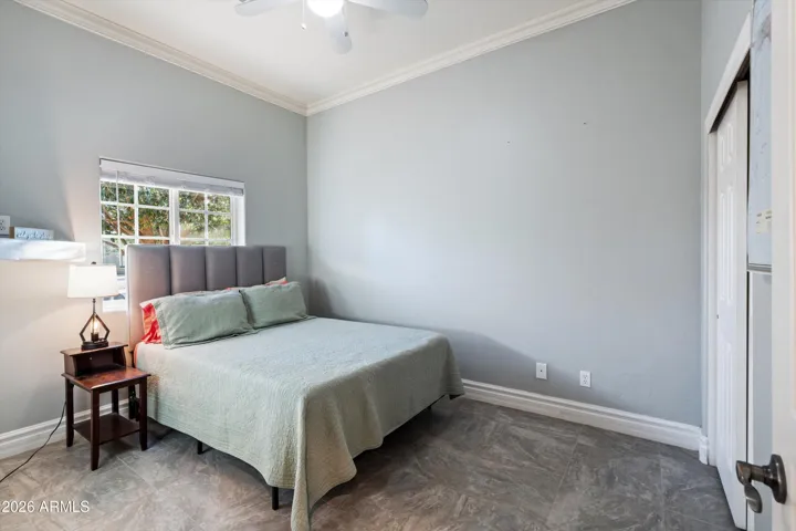 Bedroom two offers tile flooring, neutral tones, and a ceiling fan for comfort. The room provides flexibility for guests, a home office, or everyday use.