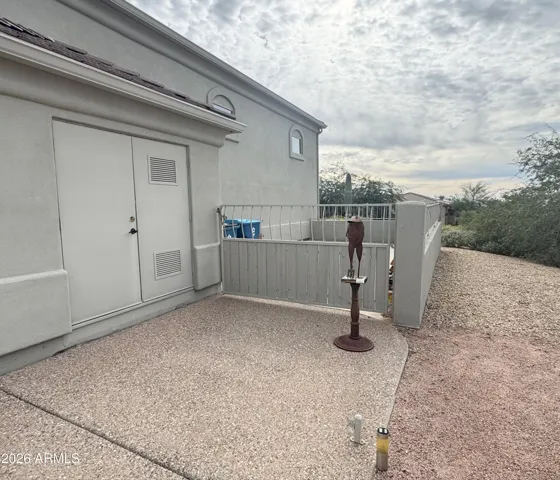 Fenced and gated trailer or toy parking pad, and exterior access to a storage room with built-in cabinets