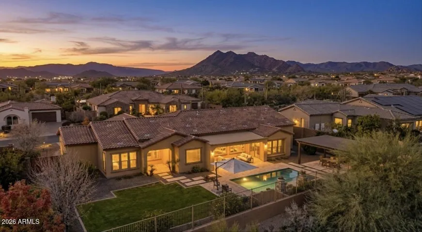 The backyard features tasteful landscape lighting that enhances the space at night.