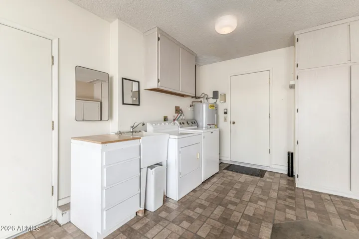 Laundry space and numerous storage cabinets and a wardrobe closet