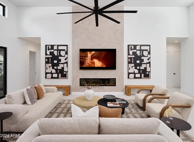 Grand open-concept living space with designer decor, featuring a fireplace and Smart TV.
