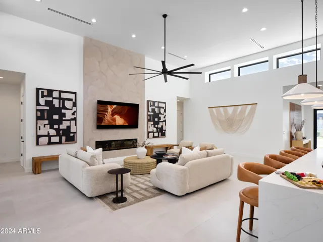Grand open-concept living space with designer decor, featuring a fireplace and Smart TV.