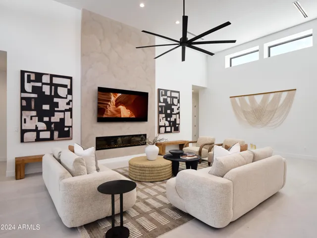 Grand open-concept living space with designer decor, featuring a fireplace and Smart TV.