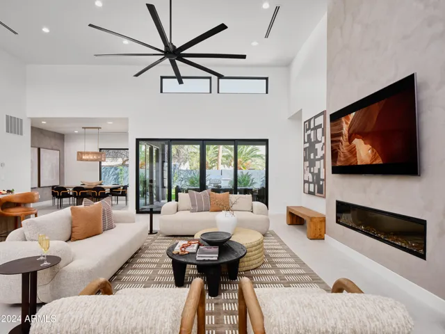 Grand open-concept living space with designer decor, featuring a fireplace and Smart TV.
