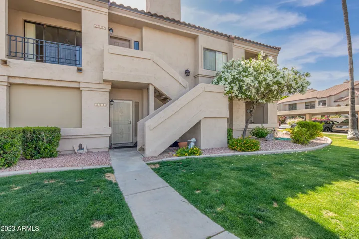 Well-maintained exterior of the Racquet Club community showcasing mature landscaping, green lawns, and classic architecture. Located in a highly desirable Scottsdale gated community with resort-style amenities.