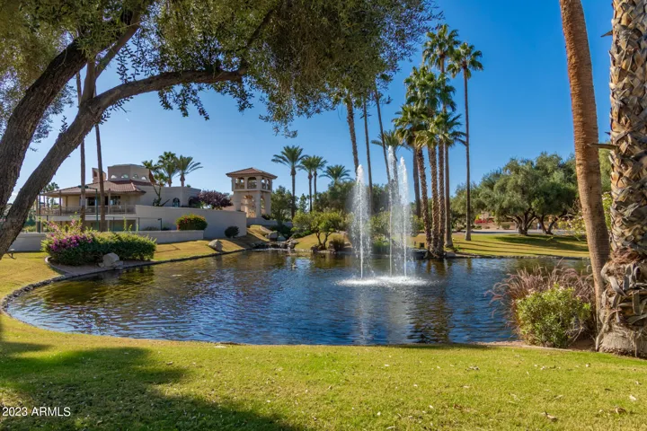 Serene lake with dramatic fountains set against manicured lawns and clubhouse architecture. Residents of this Scottsdale community enjoy tranquil water features, greenbelts, and luxury amenities.