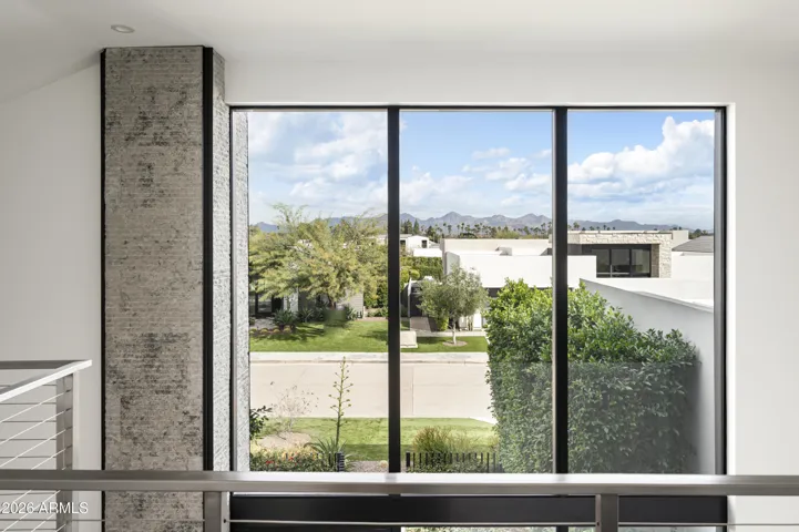 The upper level offers a versatile en suite retreat—ideal as a bedroom, office, or additional lounge—featuring a private deck with picturesque views of the McDowell Mountain Range and Mummy Mountain.