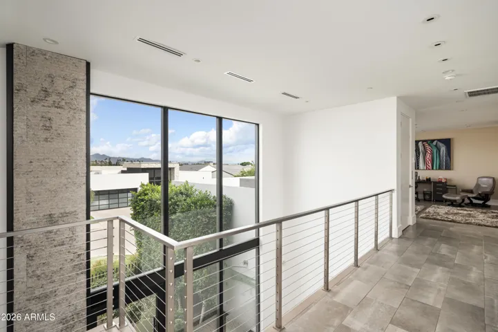 The upper level offers a versatile en suite retreat—ideal as a bedroom, office, or additional lounge—featuring a private deck with picturesque views of the McDowell Mountain Range and Mummy Mountain.