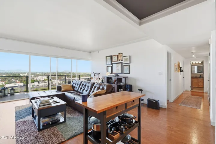 Open and light-filled living room featuring direct access to the private patio, capturing cityscape views and scenic sightlines toward Camelback Mountain. This elevated living space highlights the indoor-outdoor flow