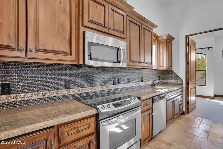Functional guest house kitchen with full stove and mini fridge, thoughtfully integrated into the living area for visitors’ comfort.