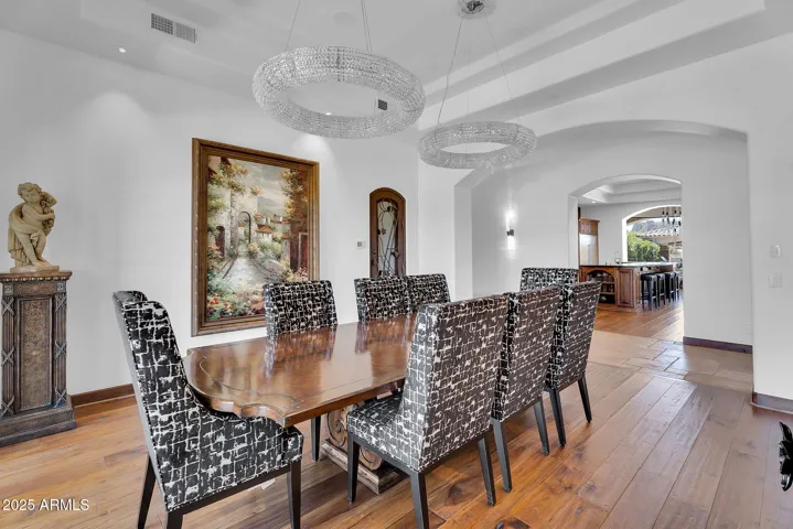 Refined formal dining room with wine room access, wood floors, and sophisticated design for hosting memorable gatherings.
