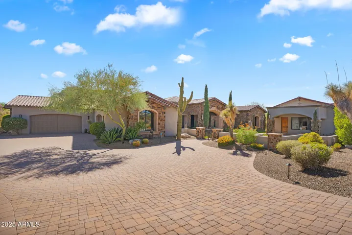 Tuscan-inspired single-level estate in North Scottsdale with Troon Mountain lush desert landscaping.