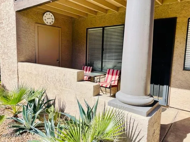 Shady front porch setting with lounge chair steps from sparkling pool and BBQs!