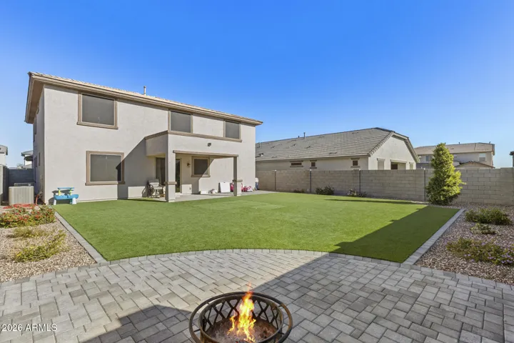 Large backyard with turf and pavers for firepit area