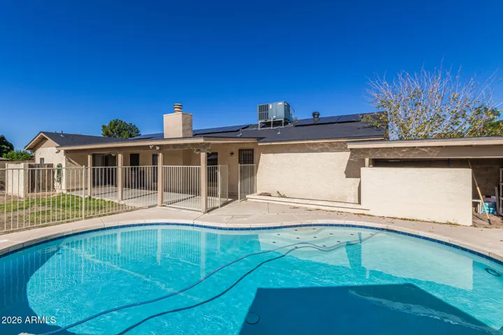 Fenced in Pool, solar panels on the south side of roof.