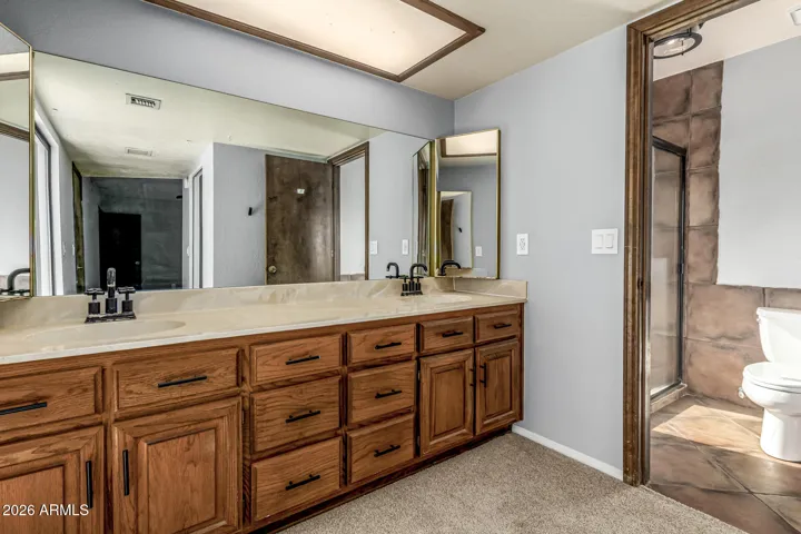 Primary bathroom with double sinks, private toilet room with garden shower