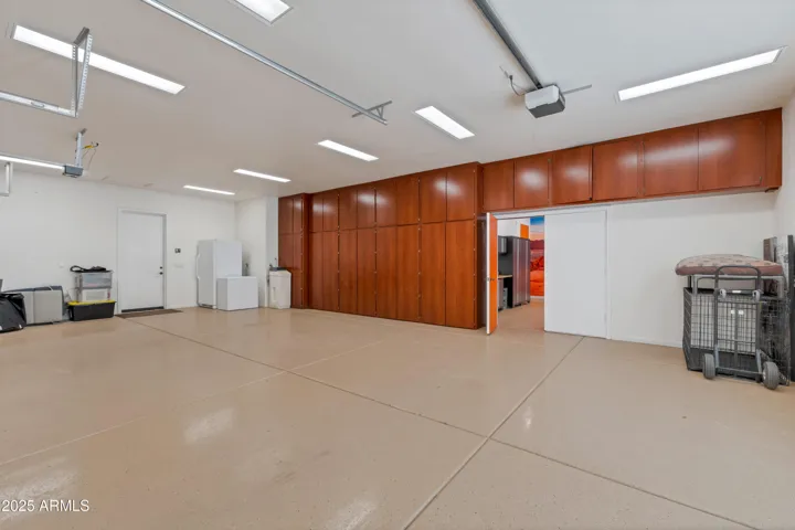 Large over-height 3 car garage, custom cabinets, access to motorcycle room