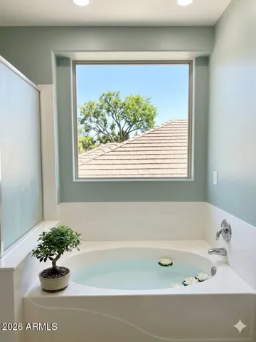 Spacious primary bathroom featuring separate soaking tub -Photos may include AI-generated or enhanced elements; actual property may differ