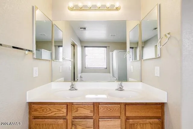 Primary bath with dual sinks and ample counter space -Photos may include AI-generated or enhanced elements; actual property may differ.
